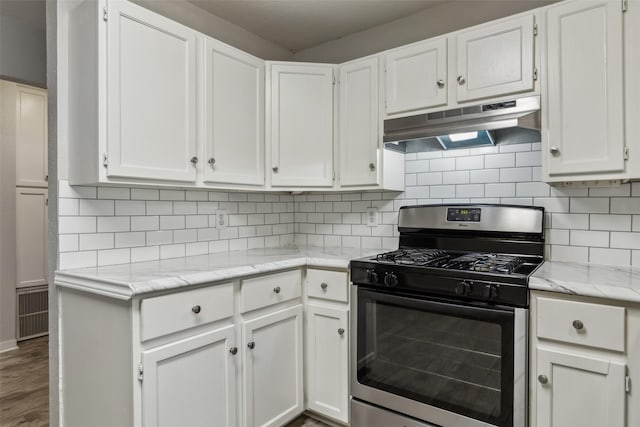 kitchen featuring white cabinetry, tasteful backsplash, light countertops, under cabinet range hood, and stainless steel gas range