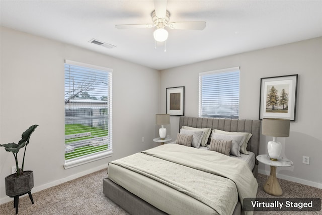 bedroom featuring multiple windows, visible vents, light carpet, and baseboards