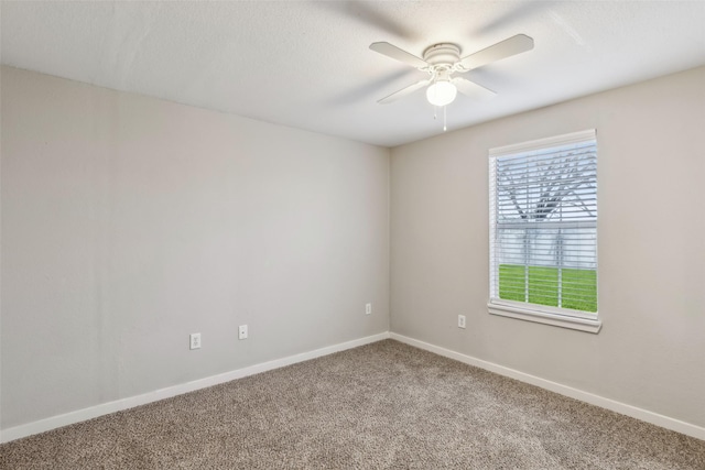 carpeted spare room featuring a ceiling fan, baseboards, and a textured ceiling