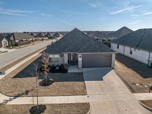 view of front of home with an attached garage, driveway, a residential view, brick siding, and a shingled roof