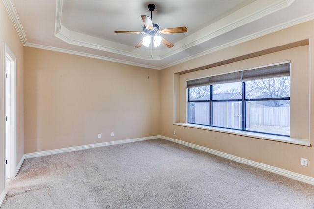 spare room featuring light carpet, crown molding, and baseboards