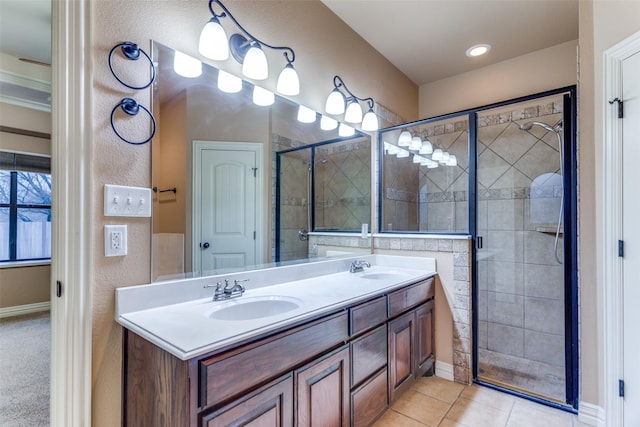 full bathroom featuring double vanity, a stall shower, a sink, and tile patterned floors