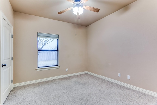 empty room featuring light colored carpet, ceiling fan, and baseboards