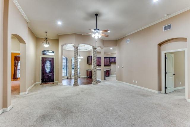 interior space with arched walkways, ceiling fan, light carpet, visible vents, and decorative columns