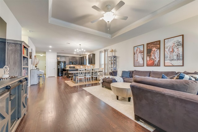 124 Feverbush Dr, Fate, TX 75189 - living area with a tray ceiling, a chandelier, a ceiling fan, dark wood finished floors, and ornamental molding