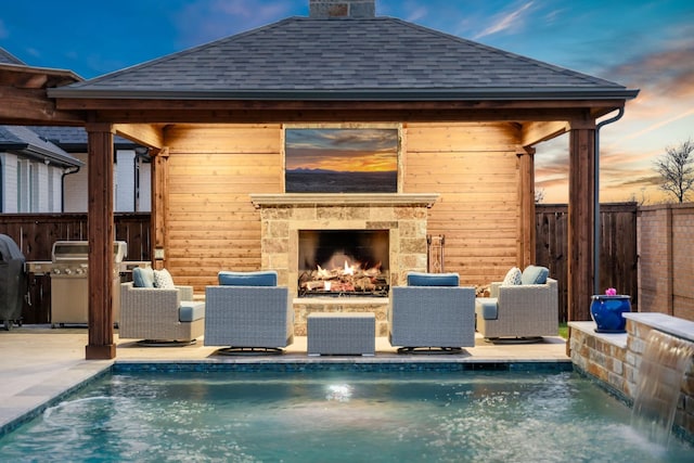 view of pool featuring fence, a gazebo, grilling area, an outdoor stone fireplace, and a fenced in pool