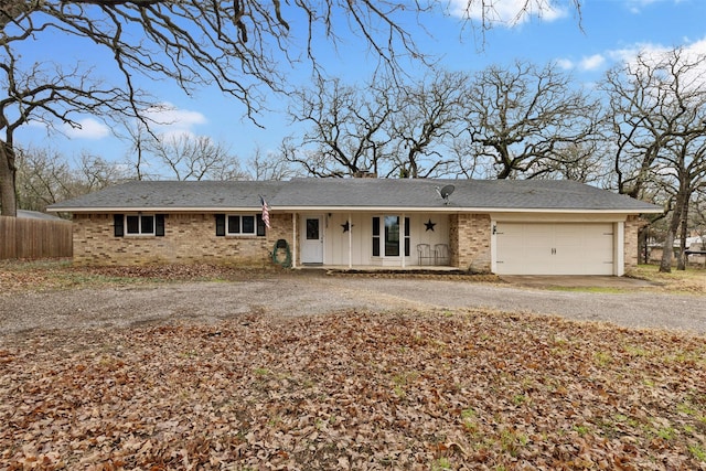 single story home featuring driveway, brick siding, a chimney, and fence