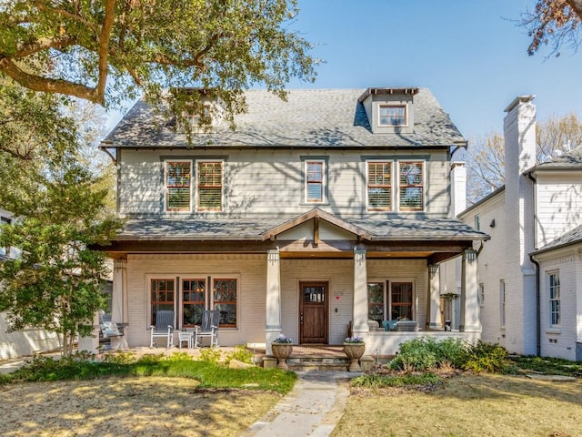 view of front of house featuring covered porch and brick siding