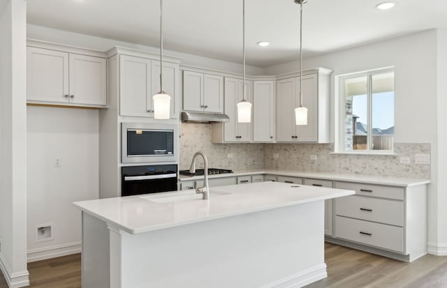5917 Mayer Ave, Pilot Point, TX 75009 - kitchen featuring black oven, stainless steel microwave, under cabinet range hood, tasteful backsplash, and recessed lighting