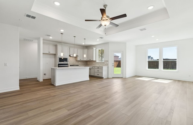 5917 Mayer Ave, Pilot Point, TX 75009 - kitchen with a tray ceiling, open floor plan, tasteful backsplash, recessed lighting, and light wood finished floors