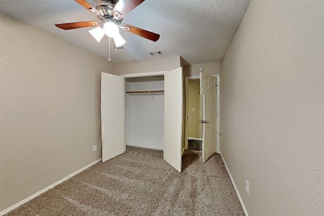 unfurnished bedroom with light carpet, a closet, visible vents, and a textured ceiling