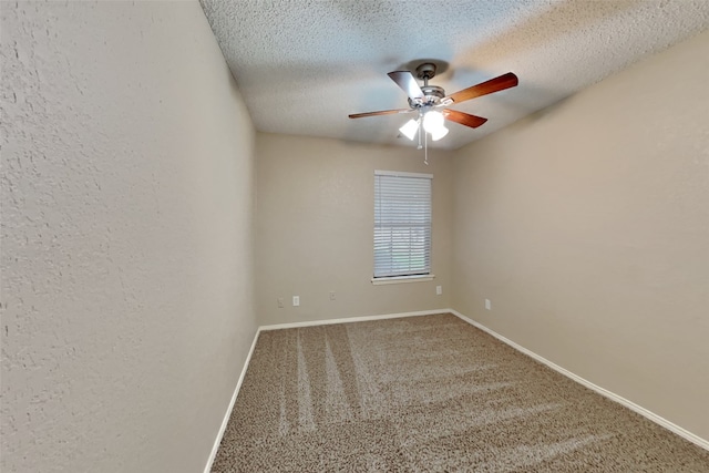 spare room featuring a textured ceiling, ceiling fan, a textured wall, carpet flooring, and baseboards