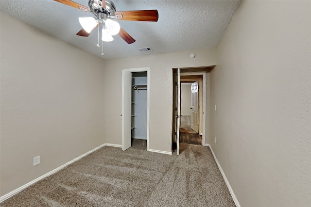 unfurnished bedroom with baseboards, visible vents, a textured ceiling, carpet floors, and a closet