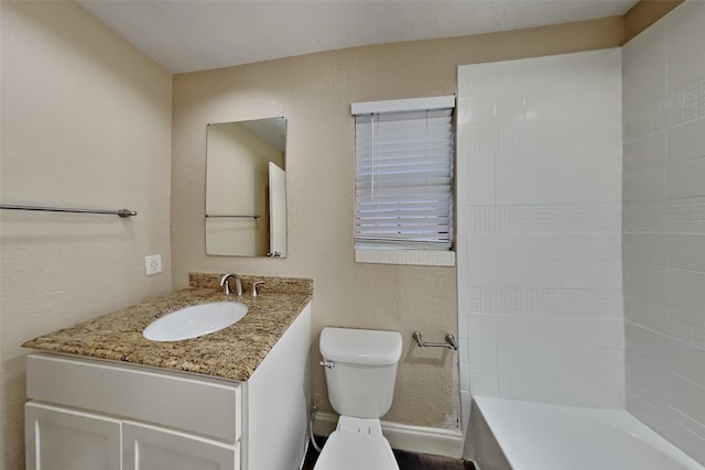 bathroom with a textured wall, vanity, toilet, and a tub