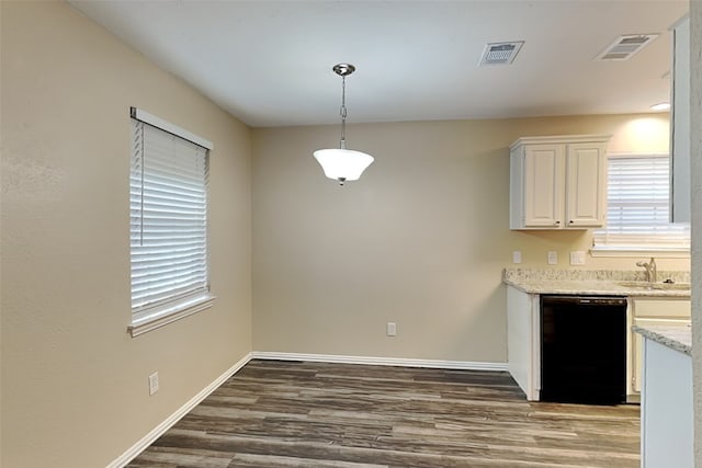 kitchen with black dishwasher, visible vents, dark wood-type flooring, decorative light fixtures, and white cabinetry