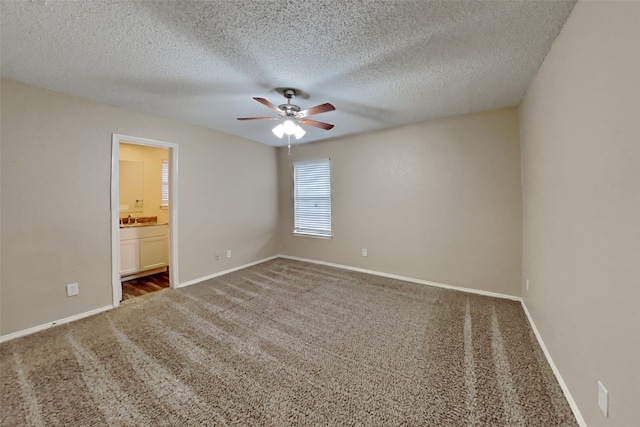 unfurnished room featuring carpet, a textured ceiling, baseboards, and a ceiling fan