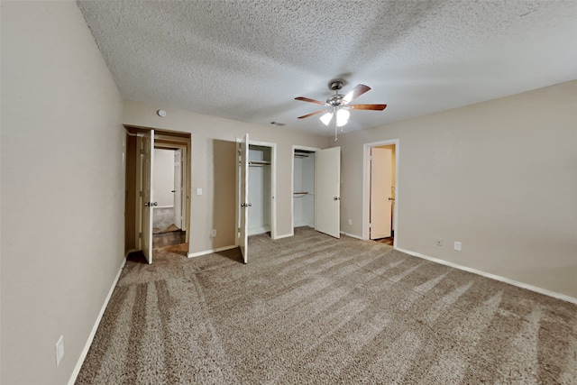 unfurnished bedroom with a ceiling fan, baseboards, a textured ceiling, multiple closets, and carpet floors