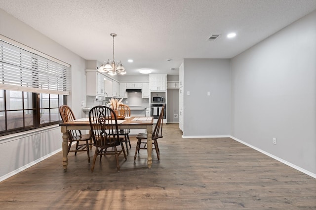 dining area featuring a textured ceiling, visible vents, and dark wood-type flooring