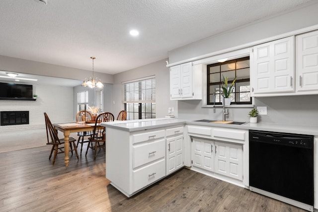 kitchen with white cabinets, dishwasher, a peninsula, hanging light fixtures, and light countertops