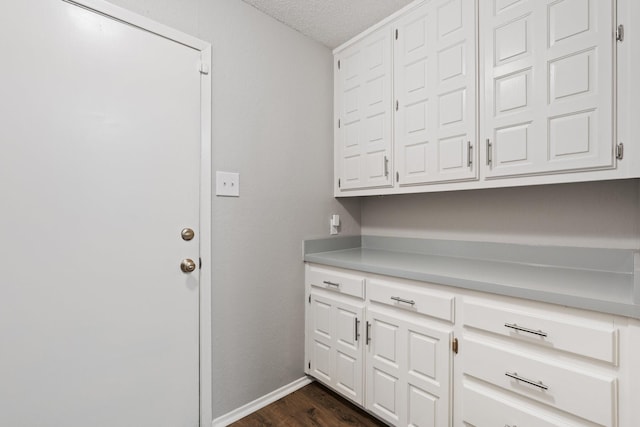 interior space with baseboards, dark wood-style floors, and a textured ceiling