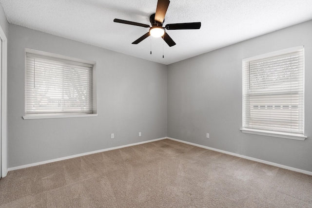 unfurnished room with baseboards, a ceiling fan, a textured ceiling, and carpet floors