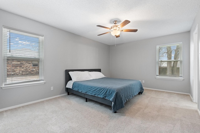 bedroom with baseboards, light colored carpet, and a textured ceiling