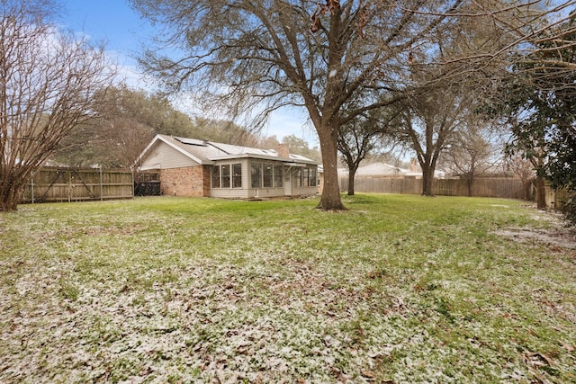 view of yard featuring a fenced backyard and a sunroom