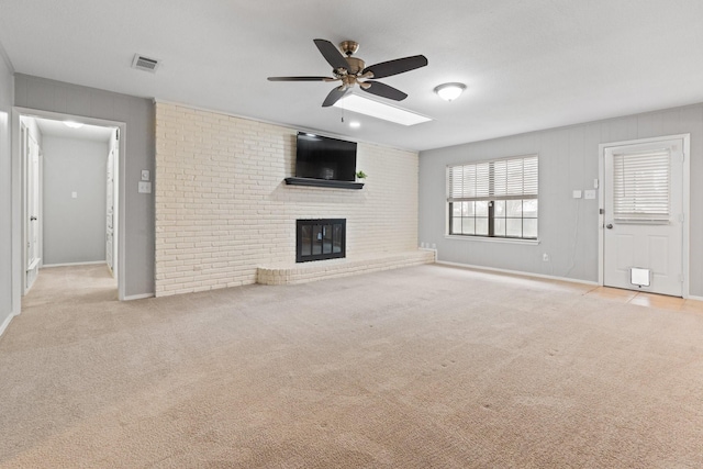 unfurnished living room with visible vents, baseboards, light colored carpet, ceiling fan, and a brick fireplace