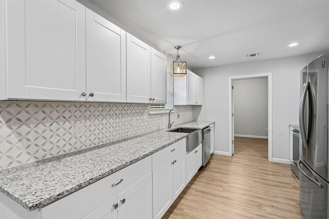 kitchen with a sink, visible vents, white cabinets, and stainless steel appliances