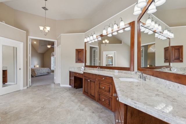 ensuite bathroom featuring double vanity, ceiling fan with notable chandelier, ensuite bath, and a sink