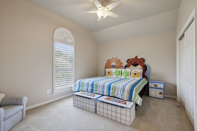 carpeted bedroom with a closet, ceiling fan, baseboards, and lofted ceiling