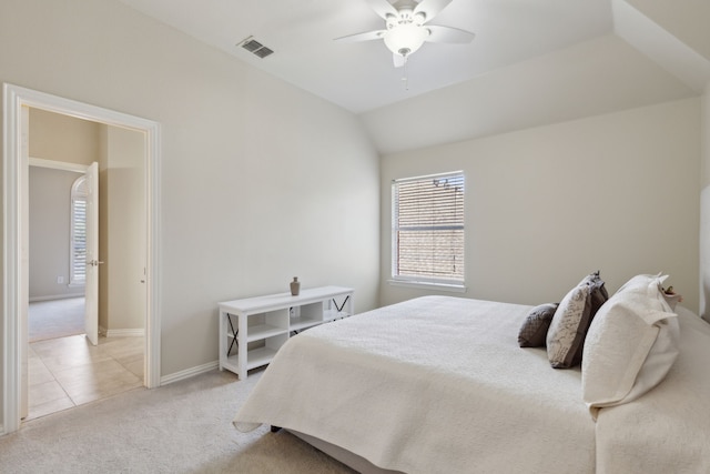 bedroom with baseboards, visible vents, light tile patterned flooring, vaulted ceiling, and light carpet