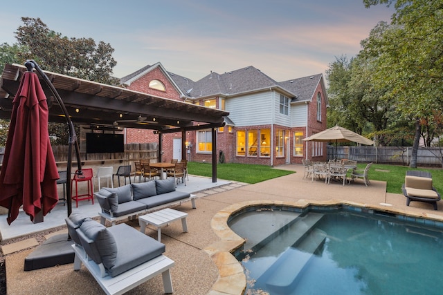 pool at dusk with outdoor dry bar, an outdoor living space, fence, a jacuzzi, and a patio