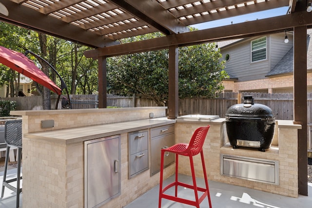 view of patio / terrace with a grill, a pergola, exterior kitchen, and a fenced backyard