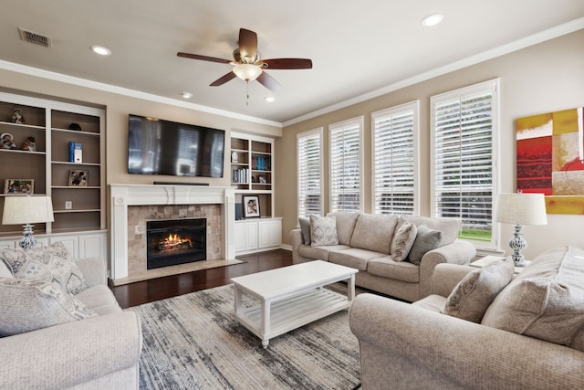 living room featuring a high end fireplace, visible vents, ornamental molding, recessed lighting, and wood finished floors