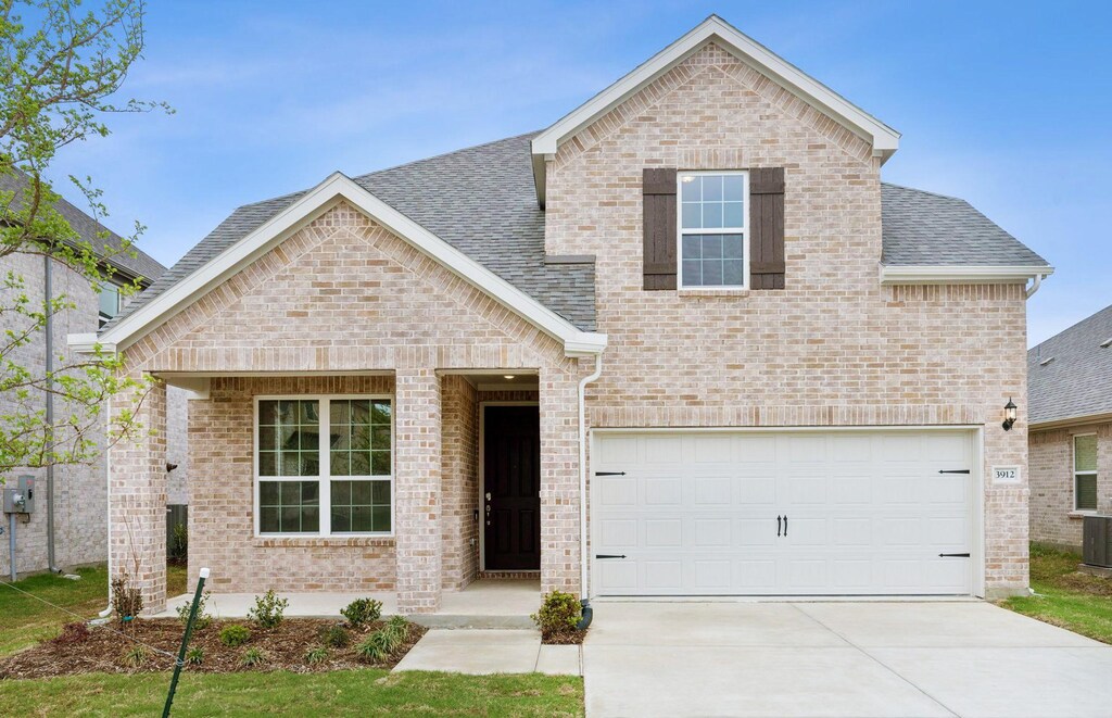 3912 Maida Rd, Mckinney, TX 75071 - view of front facade featuring brick siding, driveway, roof with shingles, and an attached garage