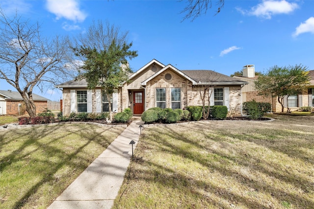 ranch-style house featuring a front yard, brick siding, and a chimney