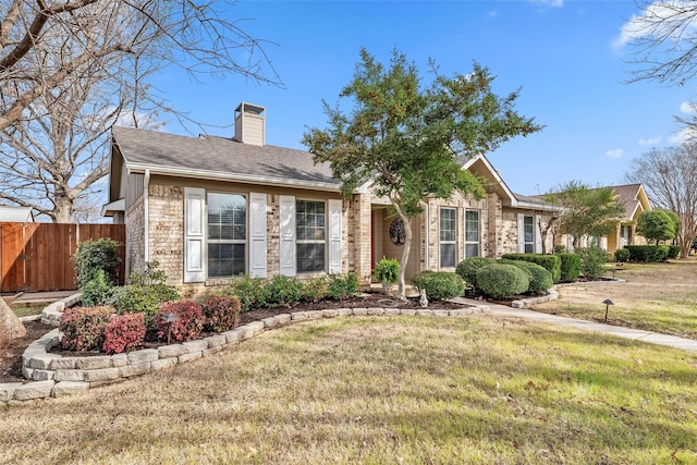 single story home featuring brick siding, roof with shingles, a chimney, a front yard, and fence