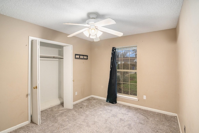 unfurnished bedroom with a textured ceiling, a closet, baseboards, and light carpet