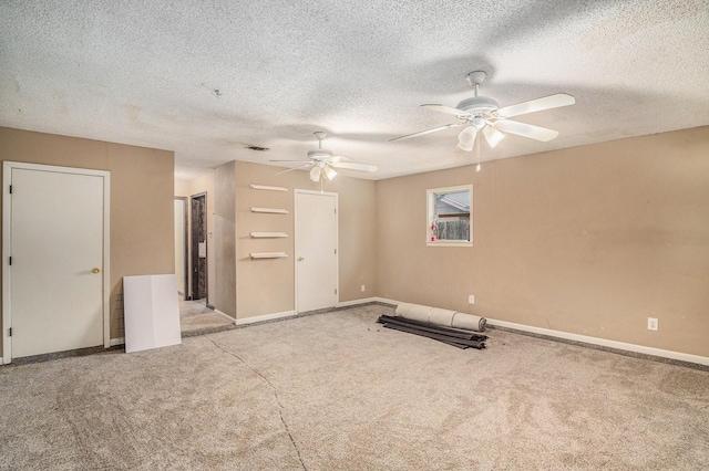 exercise area featuring baseboards, light carpet, a ceiling fan, and a textured ceiling