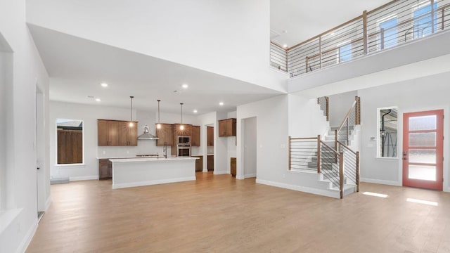 1636 Keneipp Rd, Carrollton, TX 75006 - unfurnished living room featuring stairs, light wood-type flooring, a towering ceiling, baseboards, and recessed lighting