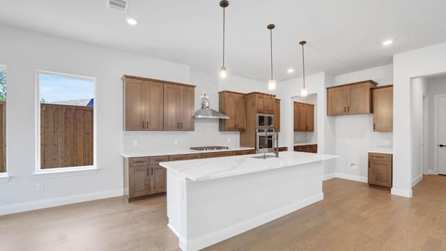 1636 Keneipp Rd, Carrollton, TX 75006 - kitchen with tasteful backsplash, brown cabinetry, pendant lighting, stainless steel appliances, and light wood finished floors