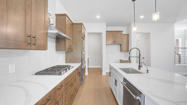 1636 Keneipp Rd, Carrollton, TX 75006 - kitchen featuring brown cabinets, a sink, light stone countertops, pendant lighting, and appliances with stainless steel finishes