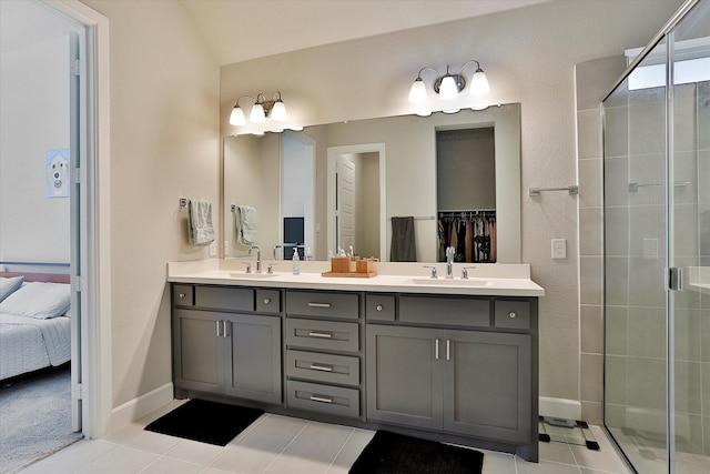 bathroom with a stall shower, double vanity, a sink, and ensuite bathroom