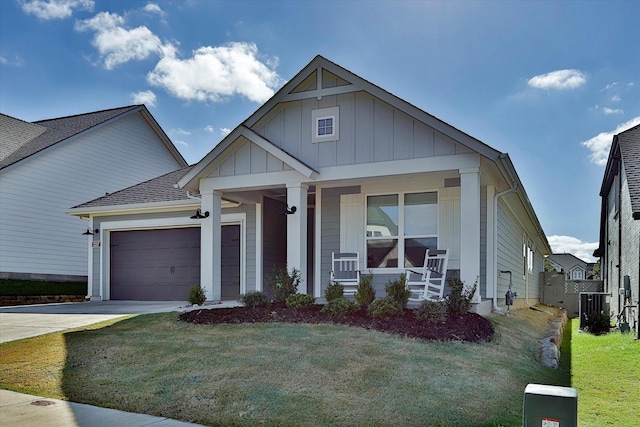 view of front of house featuring a porch, board and batten siding, a garage, driveway, and a front lawn