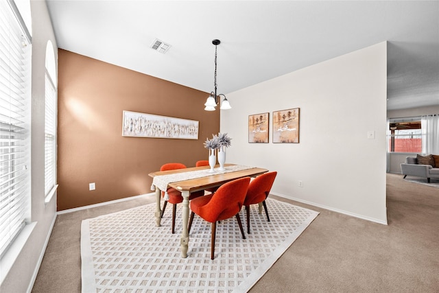 carpeted dining area with visible vents and baseboards