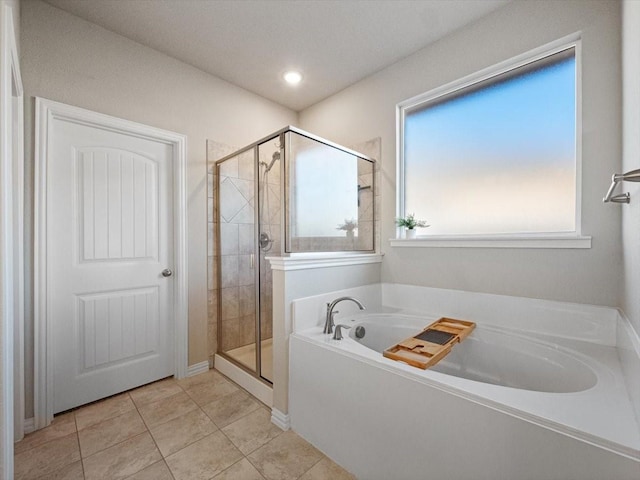 full bathroom featuring a garden tub, a shower stall, and tile patterned floors