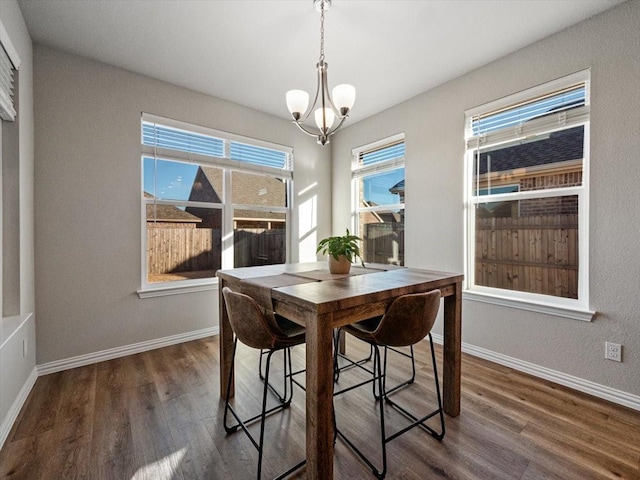 dining space with baseboards, dark wood-style flooring, and an inviting chandelier