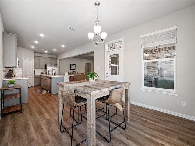 dining area with dark wood-style floors, recessed lighting, visible vents, and baseboards