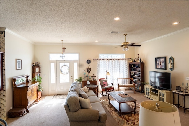 carpeted living room featuring visible vents, crown molding, a textured ceiling, and ceiling fan